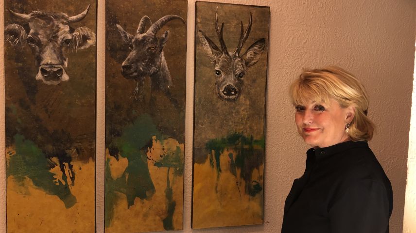 Monica Giarratana neben einer Tierporträt-Trilogie, die im Malojaner Hotel Kulm hängt.        Foto: Marie-Claire Jur
