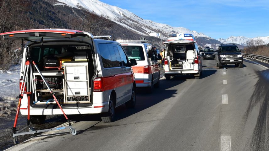 Auf der linken Seite stehen am Strassenrand drei Einsatzfahrzeuge der Rettungskräfte und der Polizei. Im Hintergrund ist ein am Unfall beteiligtes Fahrzeug zu erkennen (Foto: Kantonspolizei Graubünden).