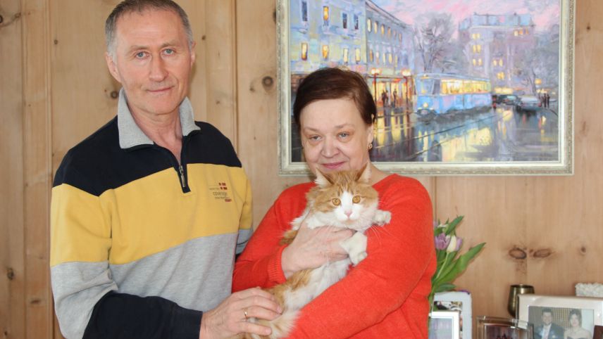 Irina Polhul und Anatolij Svartschevskij mit ihrer Katze Michelle in Samedan. Das Gemälde im Hintergrund zeigt die Stadt Winnyzja, in der Züritrams verkehren. 
