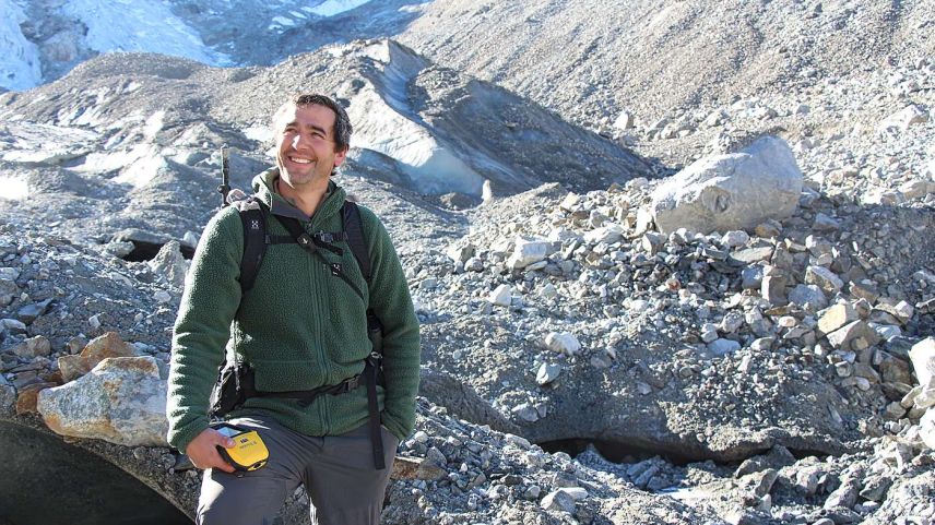 Gian Andri Godly mitten in der Eisarena des Tschiervagletschers, wo er das Gelände kritisch auf mögliche Naturgefahren hin absucht. Mit dem GPS- Gerät wird die Gletscherzunge vermessen. Foto: Stefanie Wick Widmer