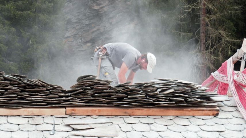 Ein Natursteindachdecker auf einer Baustelle in Sils. Schwindelfrei muss man hierfür sein - und geschickt im Umgang mit den Platten. Fotos: Denise Kley