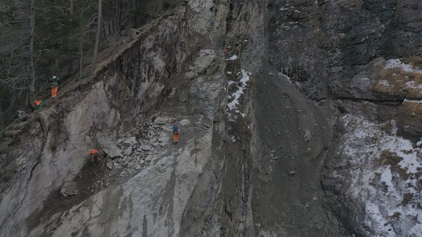 Mit Kletterseilen gesichert, entfernen Spezialisten das lose Felsmaterial. Foto: Armon Schlegel