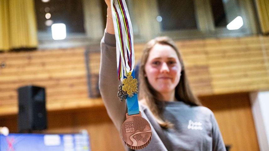 U23-WM Siegerin Marina Kälin hält die Medaillen der U23-, Junioren-WM und der YOG in die Luft. 
Foto: Academia Engiadina/Mayk Wendt