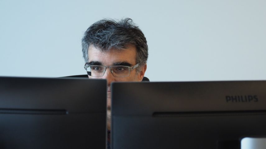 Eir ün president da la Regenza grischuna passainta bler temp da lavur davant il computer – Marcus Caduff in  seis büro a Cuoira (fotografia: David Truttmann).