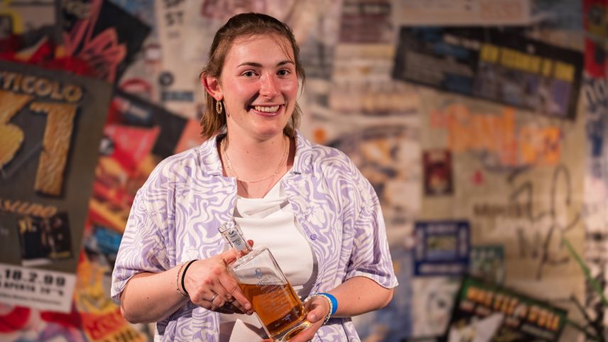 Al poetry slam rumantsch dal Festivalet, al principi da quista stà, vaiva Selina Poo da Sent surgni üna butiglia dad iva ed uschea il bigliet per rapreschantar la Rumantschia al champiunadi svizzer da poetry slam (fotografia: Gion Fry).