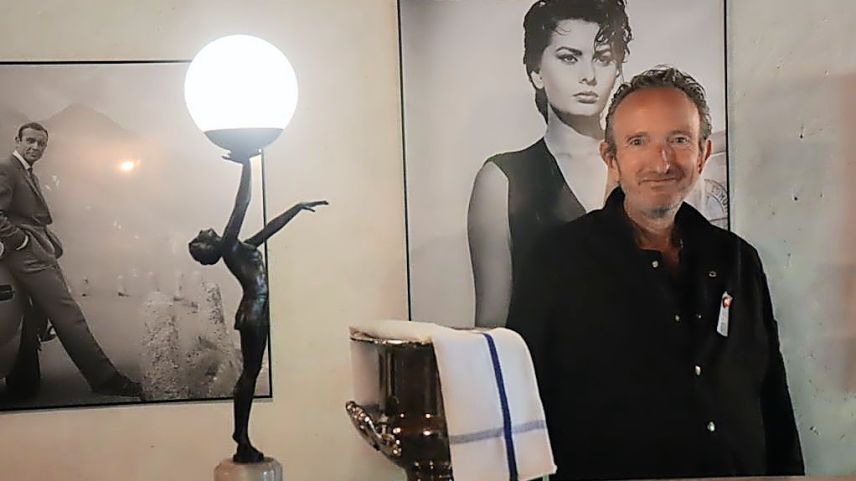 Ramun Schweizer, il possessur ed hotelier da la Chasa de Capol a Sta. Maria davant la bar da kino (fotografia: Martin Camichel).