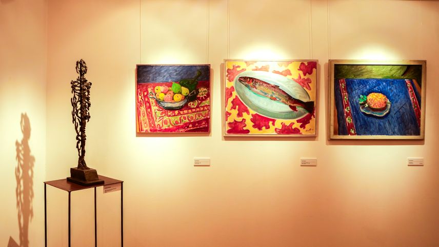 Von links: Bronzeskulptur «Halb Schatten, halb aufgelöst im Licht – Mann am Strand» von Giuliano Pedretti 2011 und drei Ölgemälde «Die grüne Birne» 1952, «Grosse Forelle auf Teller» 1953 und «Ananas» 1952 von Turo Pedretti. Fotos: Jon Duschletta