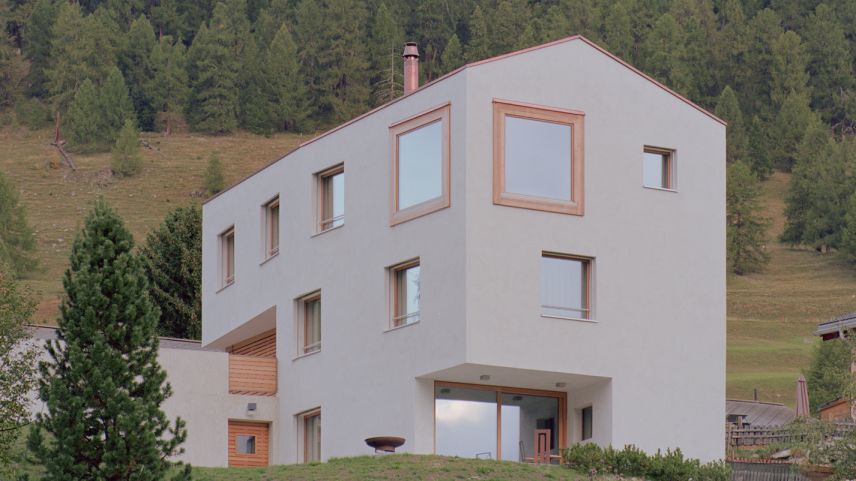 Markantes Privathaus in Brail mit polygonalem Grundriss, Lärchenfenster und kalkverputzter Fassade.  Foto: Renato Maurizio Architekten AG