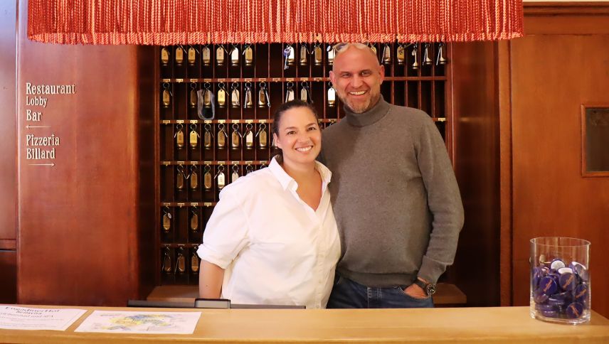 Ils nouvs osps da l’Engadinerhof a Puntraschigna daspö l’an passo: Nina Lang Esche e sieu hom Pascal Esche illa recepziun (fotografia: Martin Camichel).