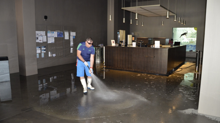 Reinigungsarbeiten im St. Moritzer Sportzentrum Ovaverva: Wasser drang in das Untergeschoss mit dem Eingang vor. Es hinterliess eine feine Sandschicht, die am Montag entfernt werden musste. Foto: Christian Gartmann