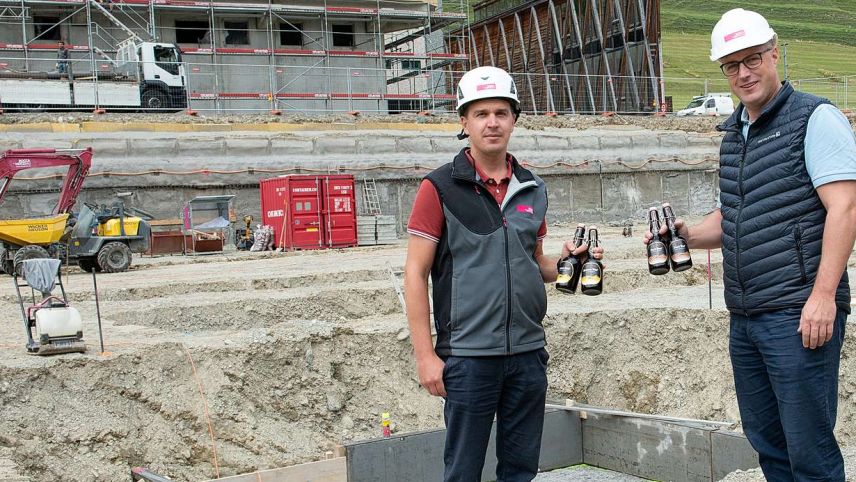 Bauführer Remo Albertin von der Firma Rocca und Hotz Bau (links) und Daniel Käslin mit den Bieren, die anlässlich der Grundsteinlegung beim Gewerbehaus Serlas einbetoniert worden sind. Foto: Reto Stifel