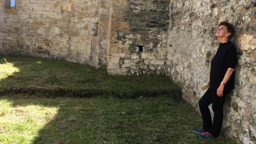 Angelika Overath illa ruina da la baselgia San Peder (fotografia: Claudia Demel).