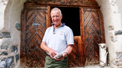 Der emeritierte Geologieprofessor Christian Dullo vor dem altehrwürdigen Haus der Stiftung A.P. Laudenbacher in La Punt Chamues-ch mit einem aus marinen Mikroorganismen entstandenen Stück Radiolarit. Foto: Jon Duschletta

