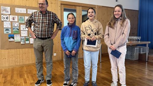 Il vicepresident da la cumischiun dal Parc Naziunal Svizzer, Christoph Flory, ha surdat in sonda a Sent ils premis a Laila Grass, Noemi Müller e Chiara Staub (fotografia: David Truttmann).