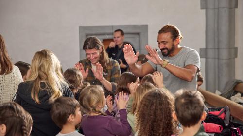 La collavuraziun  tanter giuven e «vegl» es gratiada: A dretta ingrazchan Dario Fallet e Gino Clavuot als uffants (fotografia: Michael Steiner).