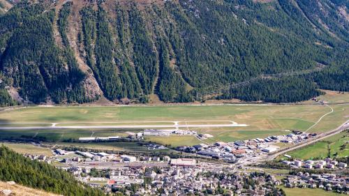 Auf der freien Fläche zwischen der Samedner Flughafeninfrastruktur und dem Wald soll das PV-Projekt Engadin Solar der Energia Solara Engiadinaisa ESE realisiert werden. Gut zu sehen sind die Lawinenzüge im Hintergrund. Archivfoto: Jon Duschletta