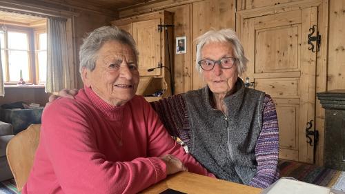 Maria Truttmann-Conrad (a schnestra) ed Anita Ruinatscha-Fasser, las anteriuras conscolaras da Müstair, as regordan insembel da lur dumengi’alba, il di cha ses bombas americanas vaivan chaschunà dons in cumün (fotografia: David Truttmann). 