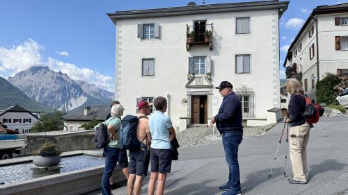 Dorfführer Domenic Bass erzählt, was es mit der Chasa dal Guvernatur auf sich hat. Foto: Fadrina Hofmann