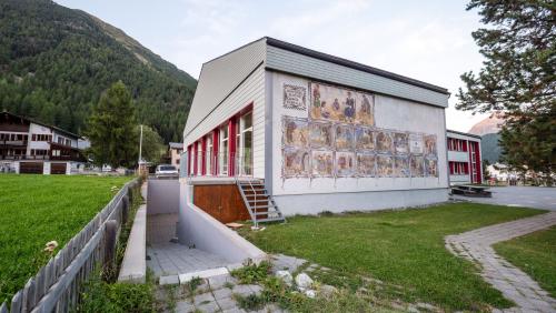 Hinteransicht des Schulhauses Bever mit dem bestehenden Fluchtweg über die Terrasse und die Metalltreppe. Foto: Jon Duschletta
